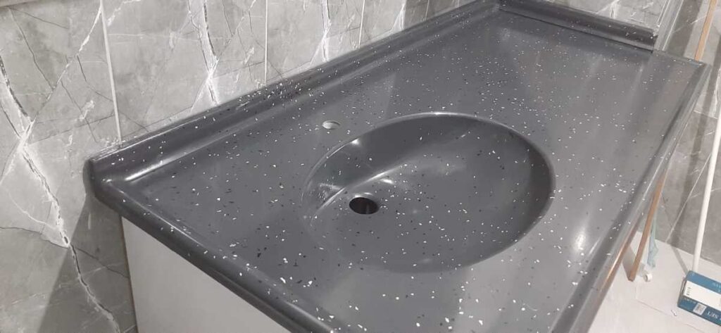 gri zemin beyaz ve siyah yapraklı mermerit banyo lavabo tezgahı